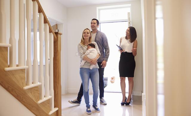 young family touring a home for sale with female agent